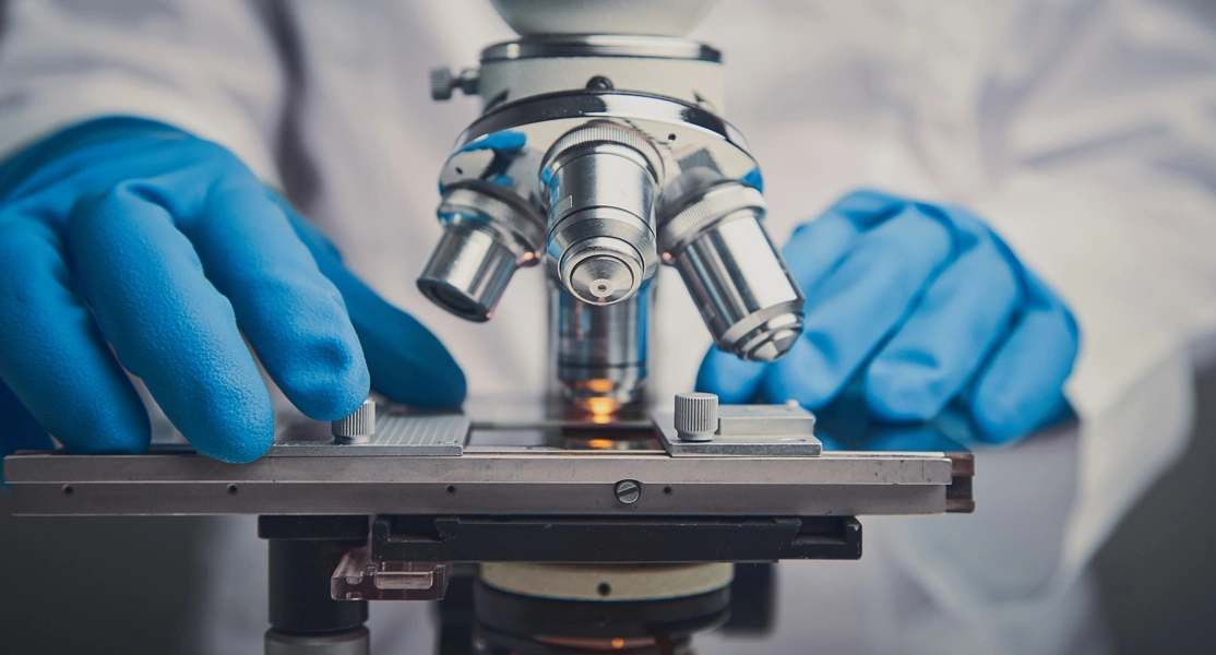 Man working at a 
                                                microscope